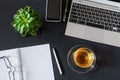 Workplace with laptop, notebook with pen, cup of tea and smartphone on dark desktop. Flat lay, top view office table desk Royalty Free Stock Photo