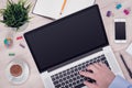 Workplace with macbook laptop on the office desk with mans hand on keyboard top view Royalty Free Stock Photo