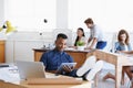 Workplace, laptop and tablet with man as architect with blueprints in office of creative company with colleagues. Male Royalty Free Stock Photo