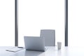 A workplace in a modern panoramic office with copy space in the windows. A white table, white leather chair.