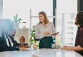 The workplace is a more motivating place because of her. a businesswoman using a digital tablet while giving a Royalty Free Stock Photo