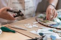 Workplace of the mosaic master: women`s hands holding tool for mosaic details in the process of making a mosaic