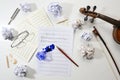 Workplace of a musician, crumpled and flat sheet of music, handwritten notation of a musical composition and an overturned inkwell Royalty Free Stock Photo