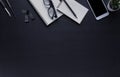 Workplace office with dark black desk. Top view from above of Empty open notebook, phone with glasses and pencil with paper clip. Royalty Free Stock Photo