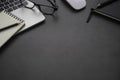 Workplace office with dark grey desk. Close-up view from above of keyboard, glasses with notebook and mouse. Tabletop space for cr Royalty Free Stock Photo