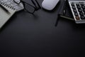 Workplace office with dark grey desk. Close-up view from above of keyboard, glasses with notebook and mouse. Royalty Free Stock Photo