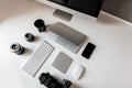 Workplace of a professional photographer. Top view on white desktop with mouse, laptop, graphics tablet, cup of coffee, keyboard