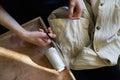 Workplace of seamstress. Dressmaker cuts dress detail, sew on buttons, spools of thread, tailor shop, tailoring, close up Royalty Free Stock Photo