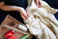 Workplace of seamstress. Dressmaker cuts dress detail, sew on buttons, spools of thread, tailor shop, tailoring, close up Royalty Free Stock Photo