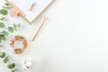 Workplace top view office tools and clipboard with cotton flowers and eucalyptus branches on a white background. Flat Royalty Free Stock Photo