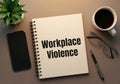 Workplace violence concept illustrated on a notebook among office desk accessories Royalty Free Stock Photo