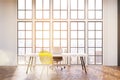 Workplace with white desk, an office chair and a transparent yellow visitor chair.