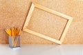 Workplace with wooden frame on cork board and pencils in pencil case on white table. Mock up design with copy space Royalty Free Stock Photo