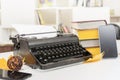 Retro and modern writer gadgets: mobile phone, old typewriter, stack of books and yellow dry leaves Royalty Free Stock Photo