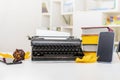 Retro and modern writer gadgets: mobile phone, old typewriter, stack of books and yellow dry leaves