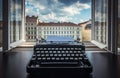 Workplace of a writer, journalist, creator. Old typewriter on the table against the background of ancient city buildings. Retro