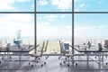 Workplaces in a modern panoramic office, New York city view from the windows. Open space. Black tables and brown leather chairs.