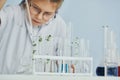 Works with test tubes. Little girl in coat playing a scientist in lab by using equipment Royalty Free Stock Photo