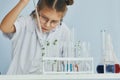 Works with test tubes. Little girl in coat playing a scientist in lab by using equipment Royalty Free Stock Photo