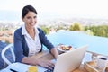 she works where ever she goes. a young businesswoman working on her laptop by a swimming pool. Royalty Free Stock Photo