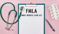 Worksheet with the inscription Family Medical Leave Act - FMLA stethoscope and pills