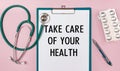 Worksheet with the inscription TAKE CARE OF YOUR HEALTH, stethoscope and pills
