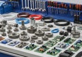 A workshop bench with an array of mechanical and electronic components. Several metal gears of Royalty Free Stock Photo