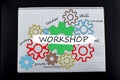 Workshop concept. View of colorful drawing of gears in notepad with different colors pens with workshop inscription