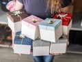 Workshop: The girl is holding a lot of multi-colored gift boxes and ribbons. Royalty Free Stock Photo