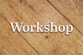 `Workshop` white text on a wooden background.