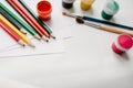 The workspace of artist for drawing. Place for text, design. Colored pencils, watercolor, paints, brush, sketchbook, white paper. Royalty Free Stock Photo