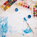 Workspace for artwork with watercolors, palette and brushes. View from above. Artistic working tools on a white table Royalty Free Stock Photo