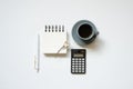 Workspace. black calculator, notepad, pen, cup of coffee on white desk background. flat lay, top view Royalty Free Stock Photo