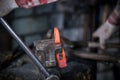 Workspace of blacksmith. Blacksmith working with red hot metal workpiece of new hammer in the vise Royalty Free Stock Photo