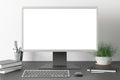 Workspace with blank computer monitor white screen mock up on the dark desk near white wall. Royalty Free Stock Photo