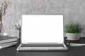 Workspace with blank laptop monitor white screen mock up on the dark desk near concrete wall. Royalty Free Stock Photo