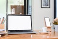 Workspace with blank screen laptop, smartphone, pencils, coffee cup and tree pot .