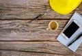 Workspace builders architect office desk, blank open notebook with pen on yellow hard hat with cup of coffee, smartphone