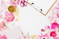 Workspace with clipboard, pastel roses and accessories on white background. Flat lay, top view. Copy space Royalty Free Stock Photo