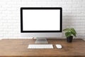 Workspace with computer with blank white screen, and office supplies on a wooden desk Royalty Free Stock Photo