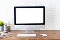 Workspace with computer with blank white screen, and office supplies on wooden desk Royalty Free Stock Photo