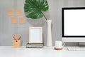 Workspace with computer, coffee mug, pencil and photo frame with sticky note on the wall Royalty Free Stock Photo