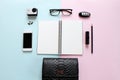 Workspace desk with blank notebook, pencil, lipstick, car key, eye glasses, small action camera, earrings, bag and smart phone on Royalty Free Stock Photo