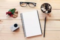 Workspace desk with notebook, pencil, pine cones in tea wooden cup, eye glasses, red flower and small action camera on wooden back Royalty Free Stock Photo