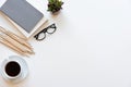 Workspace desk. Top view office desk with notebook, pencils, glasses and plant on white background. Royalty Free Stock Photo