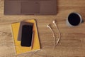 Workspace desk. Top view to yellow notepad with mobile phone, white headpnones and part of laptop Royalty Free Stock Photo