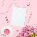 Home office workspace. Notebook with copyspace. Woman fashion accessories and flowers on pink background. Royalty Free Stock Photo