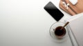 Workspace on dinning table with copy space, smartphone, schedule books, teacup, earphone on wooden tray