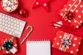 Workspace with keyboard and christmas gift and candy cane on red background flat lay top view, copy space Business christmas Royalty Free Stock Photo