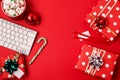 Workspace with keyboard and christmas gift and candy cane on red background flat lay top view, copy space Business christmas Royalty Free Stock Photo